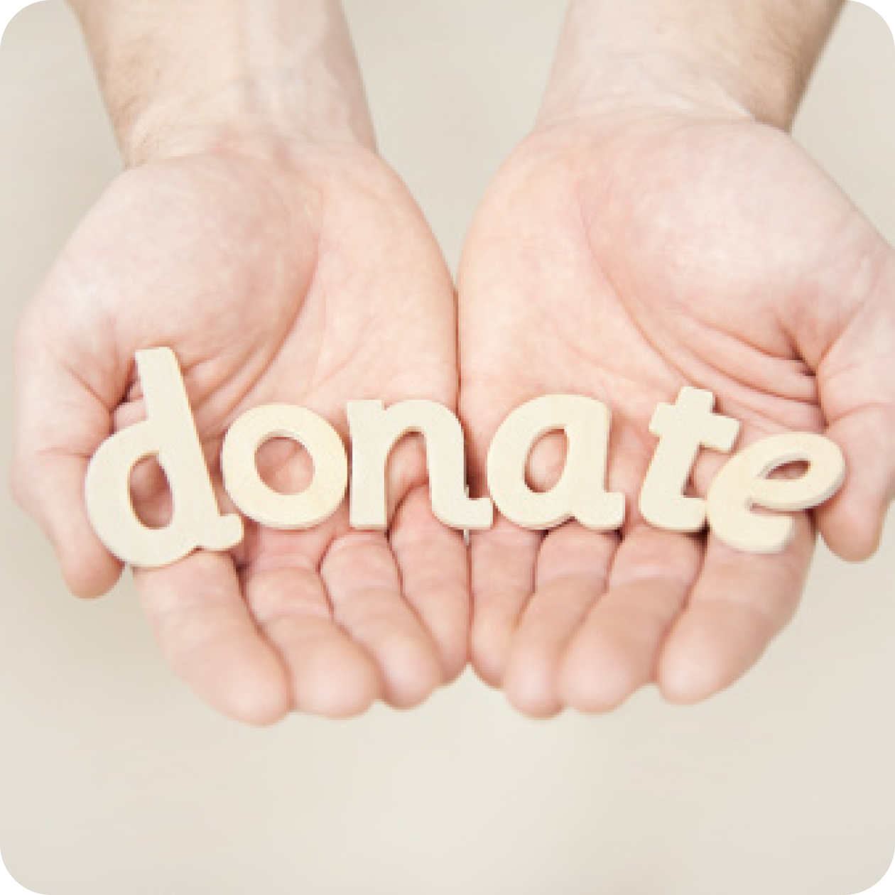 Image of two hands with palms facing up, extended toward the viewer, holding the word donate.